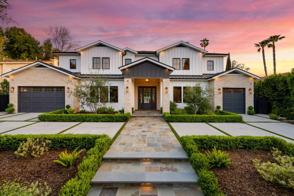 House encircled by lush green hedges and palm trees